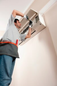 technician-performing-maintenance-on-a-ductless-AC-air-handler