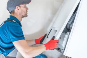a-heating-technician-opening-a-furnace-to-perform-maintenance